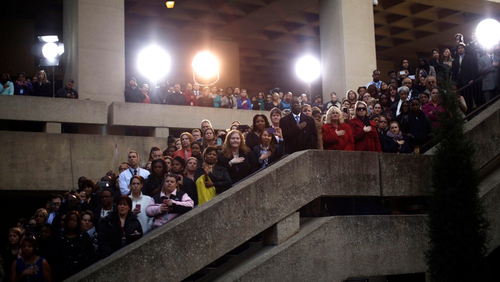 FBI staff watch the swearing-in of FBI Director James Comey at the FBI headquarters in Washington