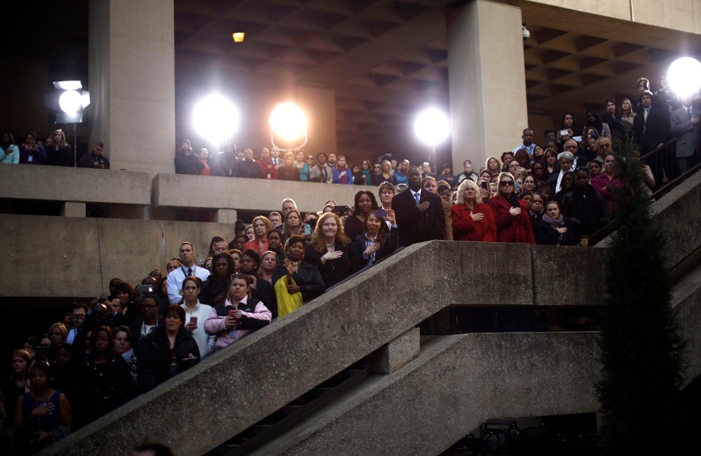 FBI staff watch the swearing-in of FBI Director James Comey at the FBI headquarters in Washington