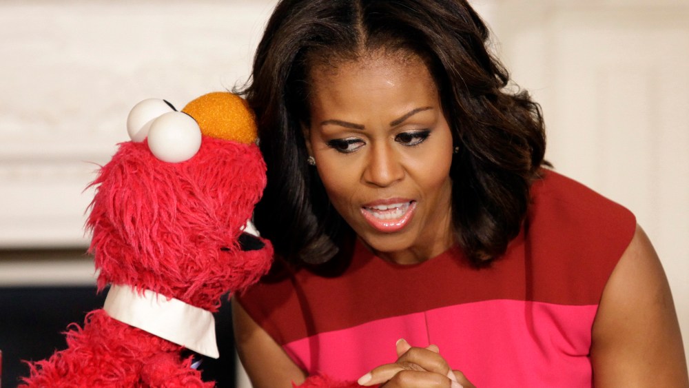 U.S. first lady Michelle Obama listens to Sesame Street character Elmo after delivering remarks on marketing healthier foods to children at the White House, October 30, 2013.