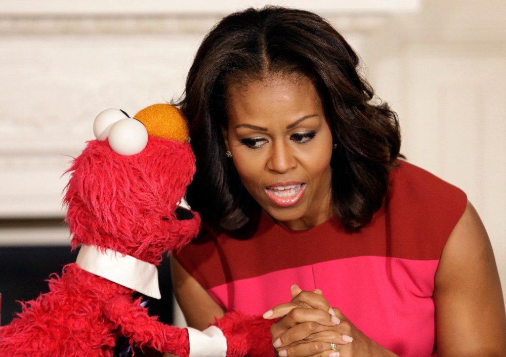 U.S. first lady Michelle Obama listens to Sesame Street character Elmo after delivering remarks on marketing healthier foods to children at the White House, October 30, 2013.
