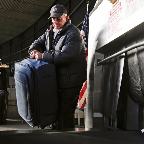 Sky Cap worker Tim Weiler, 67, checks curbside luggage at Seattle-Tacoma International Airport in SeaTac, Washington, October 30, 2013.