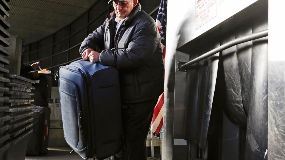 Sky Cap worker Tim Weiler, 67, checks curbside luggage at Seattle-Tacoma International Airport in SeaTac, Washington, October 30, 2013.