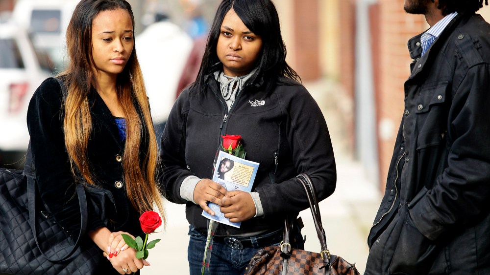 Mourners hold roses after the funeral service for 19-year-old shooting victim Renisha McBride in Detroit, Michigan, November 8, 2013.