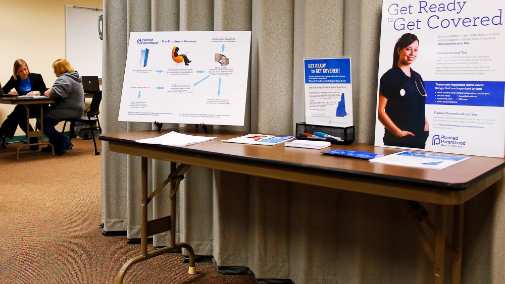 A navigator helps a woman seeking health insurance at an enrollment fair in Portsmouth, NH, Nov. 9, 2013.