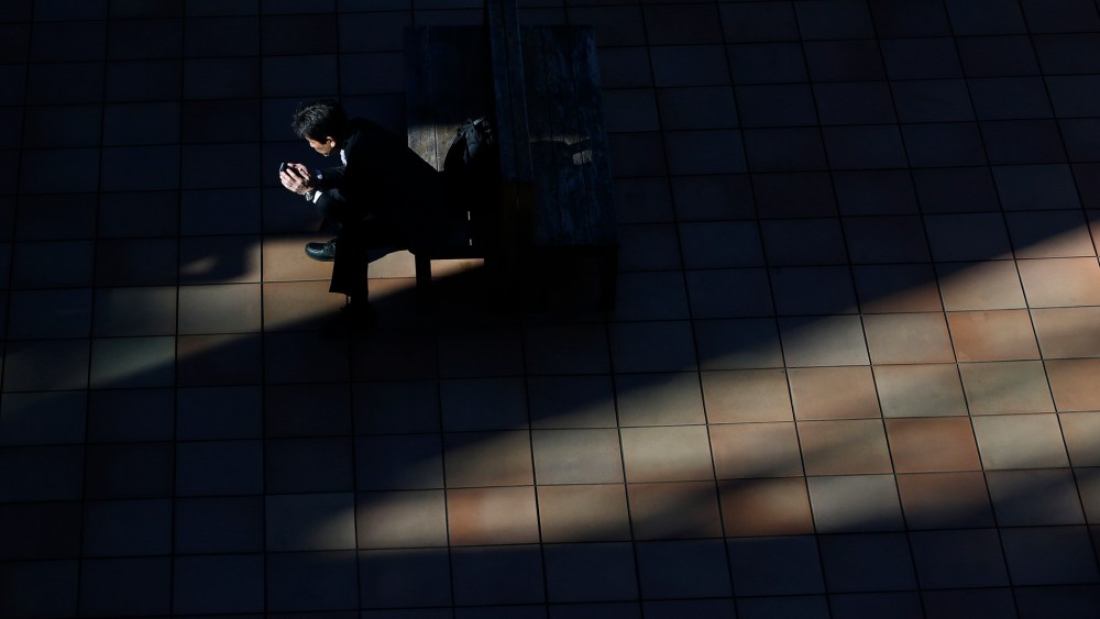 A man uses a smartphone on a street in Tokyo