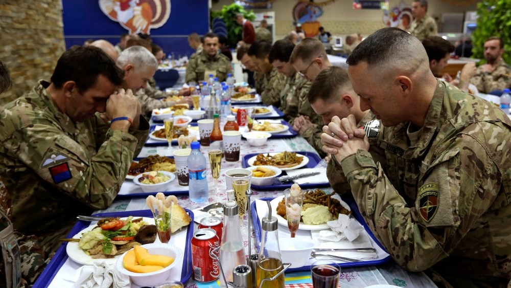 U.S. troops pray before eating during a Thanksgiving meal at a NATO base in Kabul