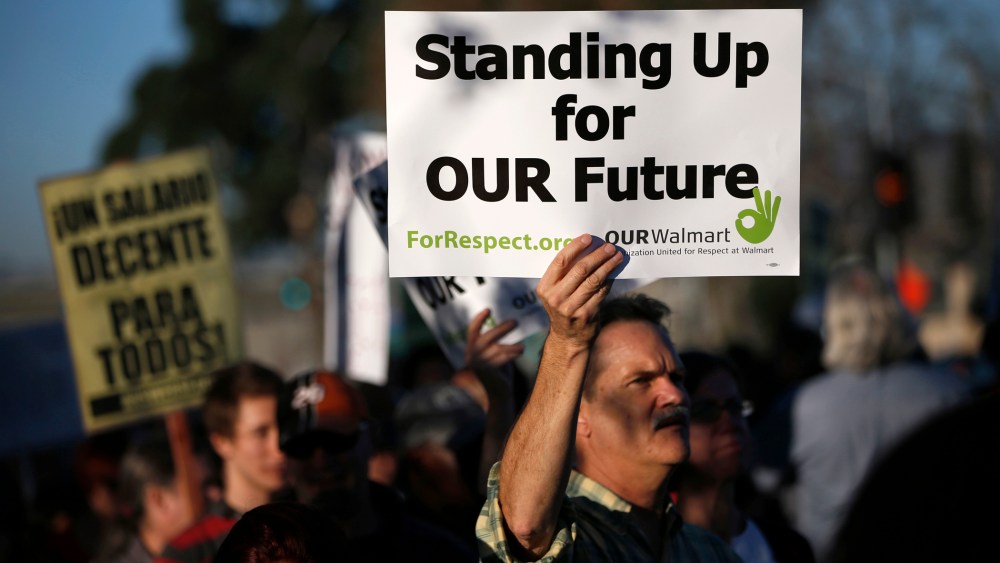 A demonstrator holds up a sign during a protest outside Wal-Mart for better wages and working conditions during Black Friday in San Leandro, Calif. on Nov. 29, 2013.