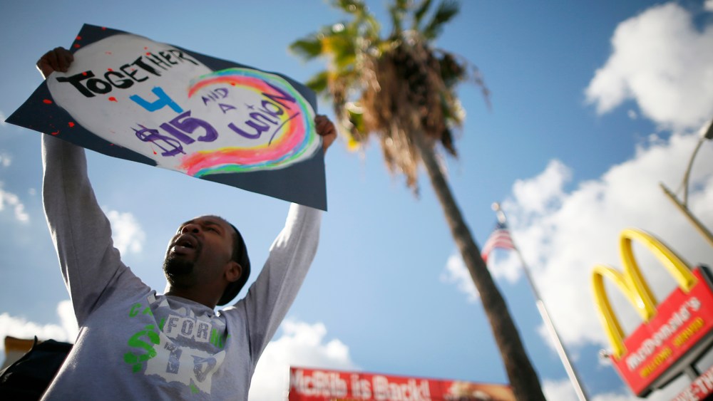 Joe Ben Johnson III holds a sign outside McDonald's in Los Angeles, Calif. on Dec. December 5, 2013.