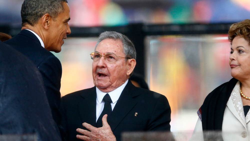 Barack Obama greets Cuban President Raul Castro before giving his speech, as Brazil's President Dilma Rousseff looks on, at the memorial service for Nelson Mandela, Dec. 10, 2013.