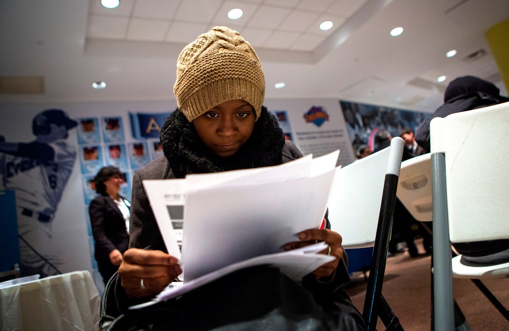A woman fills out paperwork at a job training and resource fair at Coney Island in New York Dec. 11, 2013.
