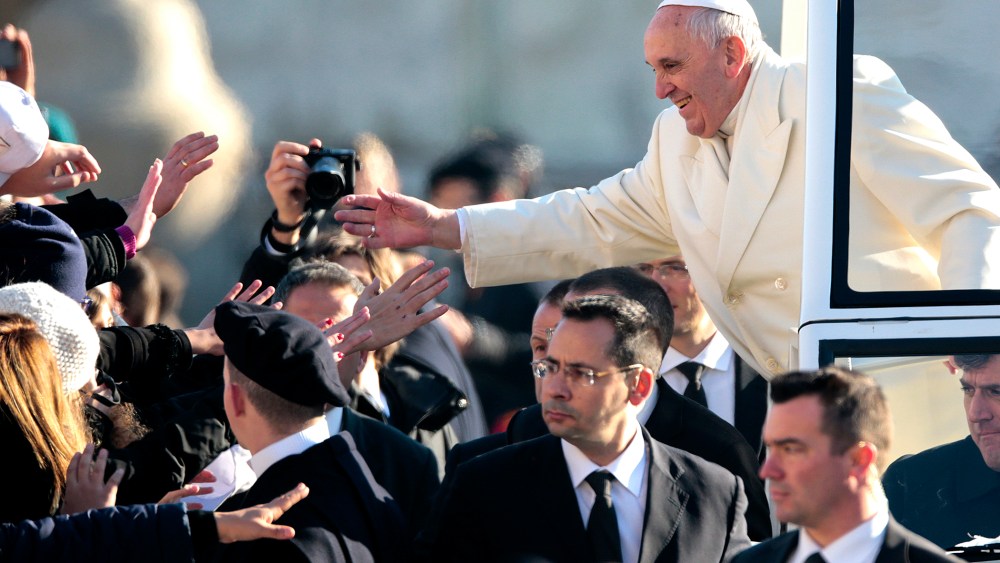 Pope Francis gives blessings as he arrives to lead his Wednesday general audience in Saint Peter's square at the Vatican Dec. 18, 2013.