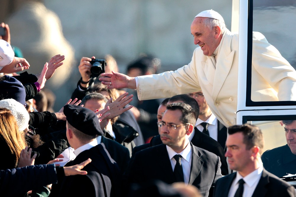 Pope Francis gives blessings as he arrives to lead his Wednesday general audience in Saint Peter's square at the Vatican Dec. 18, 2013.