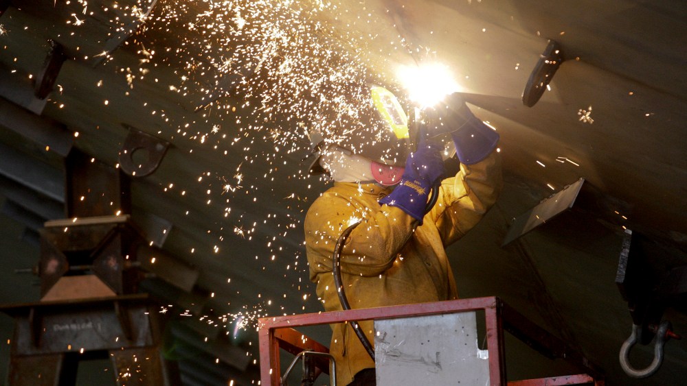 Vigor Industrial employee welds metal on a ferry being built for Washington State Ferries at the company's Harbor Island centre in Seattle