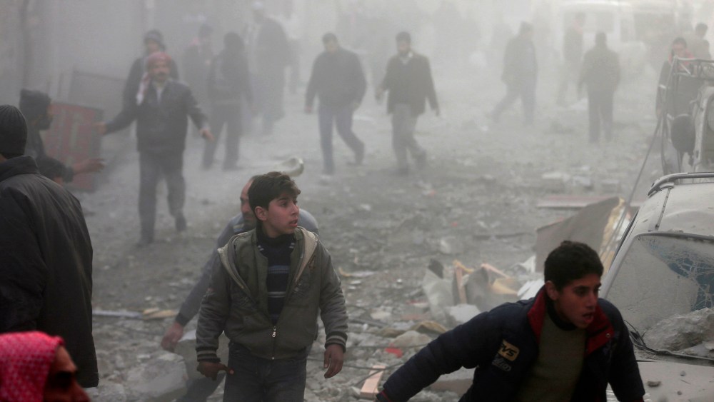 People rush after what activists said was an airstrike by forces loyal to Syrian President Bashar al-Assad in the Duma neighbourhood of Damascus