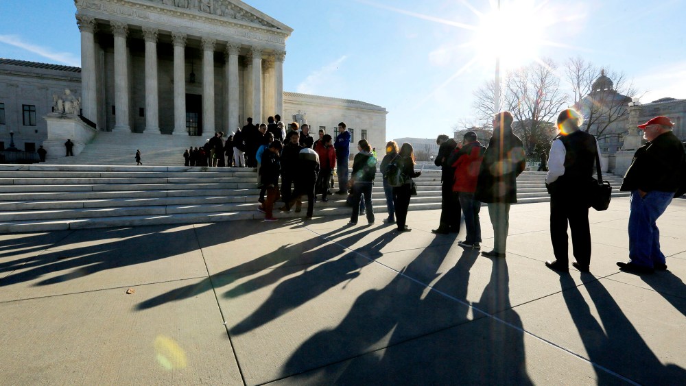 Members of the public cast shadows as they line up in front of the U.S. Supreme Court in Washington