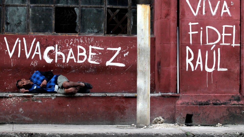 A man sleeps near graffiti in Havana on Jan. 16, 2014.