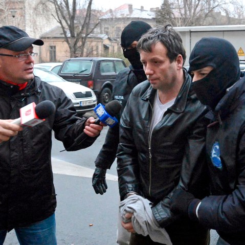 Marcel Lazar Lehel, 40, is escorted by masked policemen in Bucharest, after being arrested in Arad, 550 km (337 miles) west of Bucharest, Jan.22, 2014. (Photo by Silviu Matei/Mediafax/Reuters)