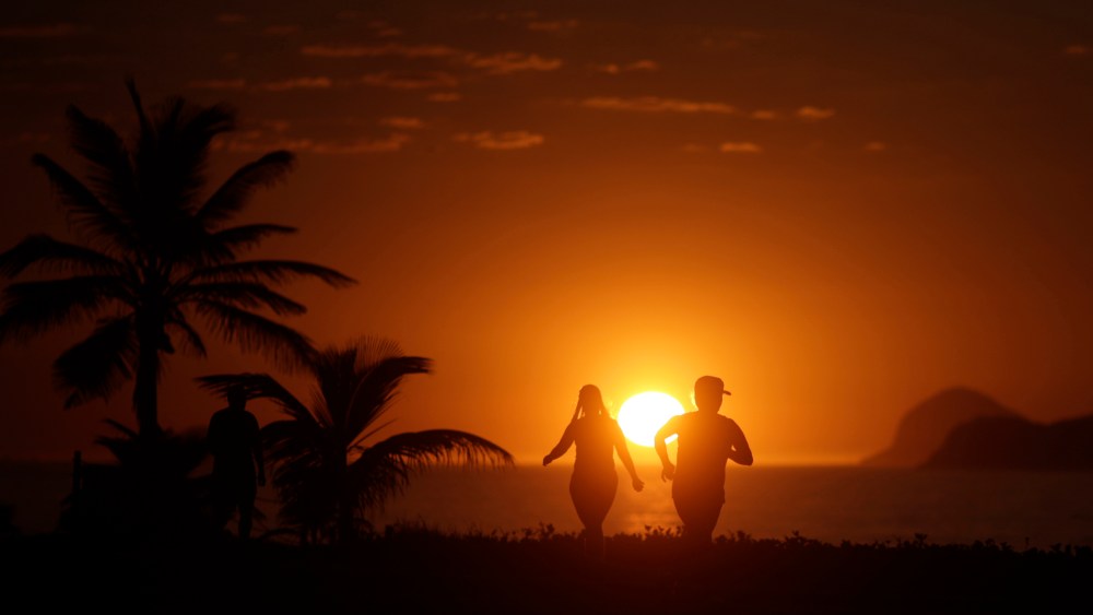 People exercise in Barra da Tijuca beach during the sunrise in Rio de Janeiro (Photo by Ricardo Moraes/Reuters)