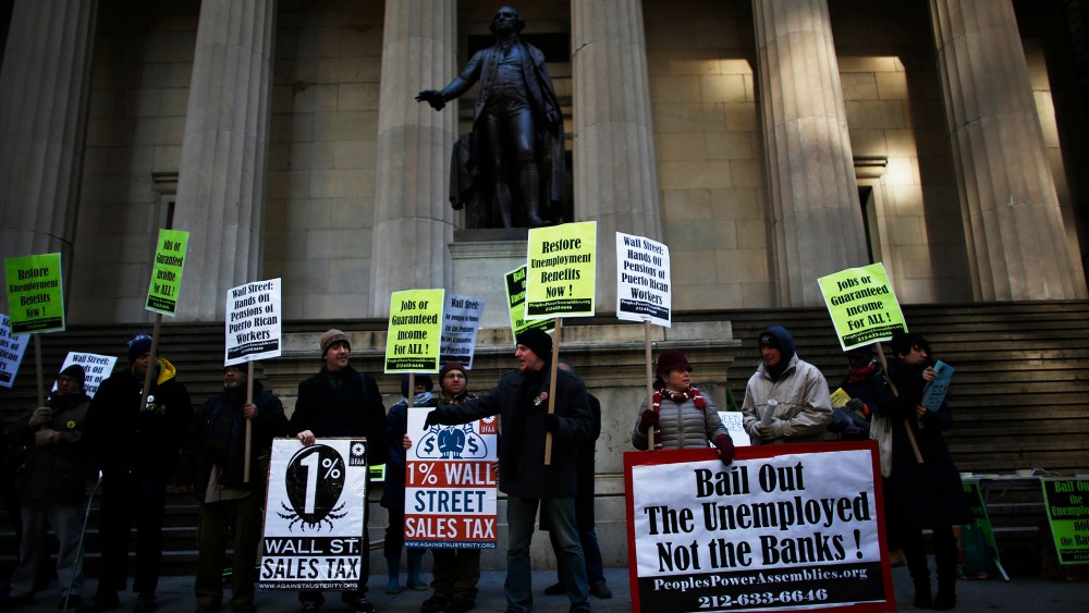 Members of Occupy Wall Street and People Power Assembly take part in a protest demanding restoration of extended unemployment benefits next to the New York Stock Exchange in New York