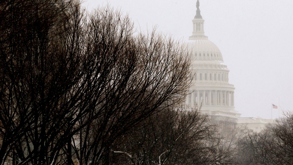 A pedestrian walks across New Jersey Avenue in front of the U.S. Capitol building.