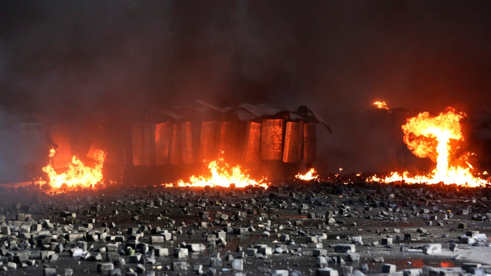 Interior ministry members take cover behind shields during clashes with anti-government protesters in Kiev, Feb. 18, 2014.