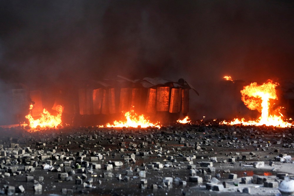 Interior ministry members take cover behind shields during clashes with anti-government protesters in Kiev, Feb. 18, 2014.