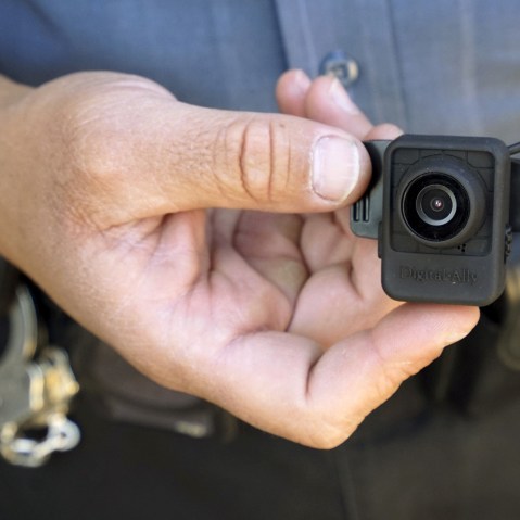 A Colorado Springs police officer poses with a Digital Ally First Vu HD body worn camera outside the police department in Colorado Springs April 21, 2015. (Photo by Rick Wilking/Reuters)