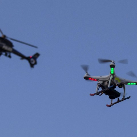 A police helicopter flies past a UAV drone Quadcopter which was flying over a post-march street celebration in west Baltimore, Md., May 2, 2015. (Photo by Adrees Latif/Reuters)