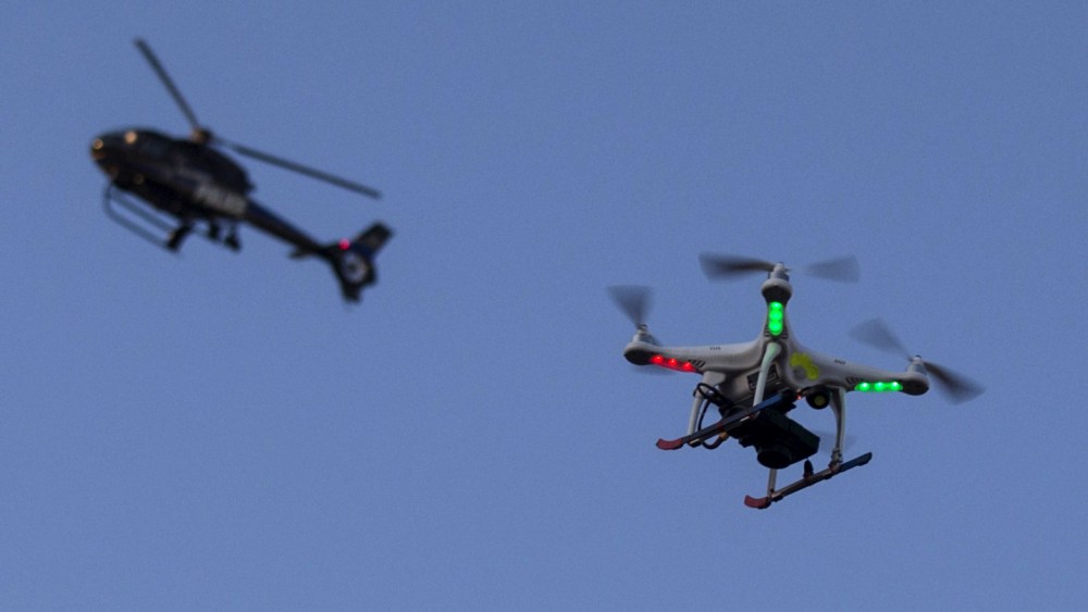 A police helicopter flies past a UAV drone Quadcopter which was flying over a post-march street celebration in west Baltimore, Md., May 2, 2015. (Photo by Adrees Latif/Reuters)