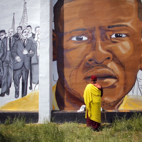 Gyalwang Drukpa, a Buddhist leader from South Asia, prays in front of a mural of Freddie Gray in Baltimore, Md., May 7, 2015. (Photo by Carlos Barria/Reuters)
