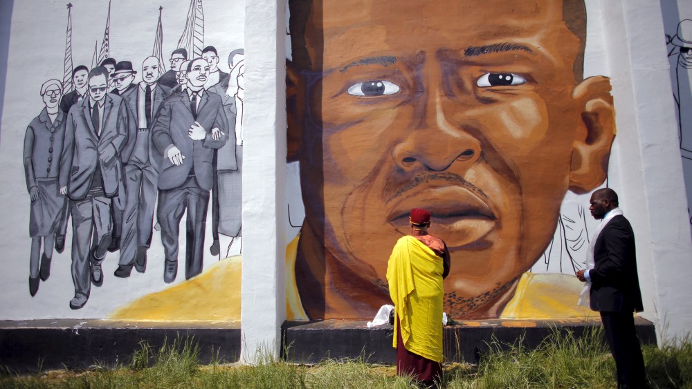 Gyalwang Drukpa, a Buddhist leader from South Asia, prays in front of a mural of Freddie Gray in Baltimore, Md., May 7, 2015. (Photo by Carlos Barria/Reuters)