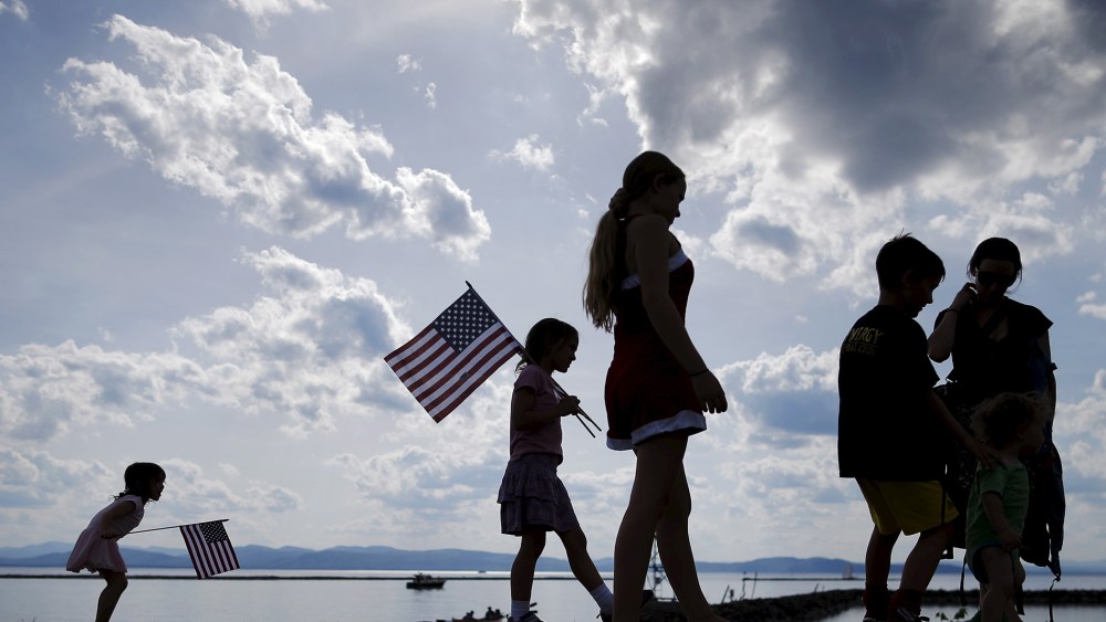 A Vermont family waits for U.S. Senator Bernie Sanders to kick off his presidential campaign on the shore of Lake Champlain in Burlington, which is lined by New York mountains on the horizon, May 26, 2015. (Photo by Brian Snyder/Reuters)