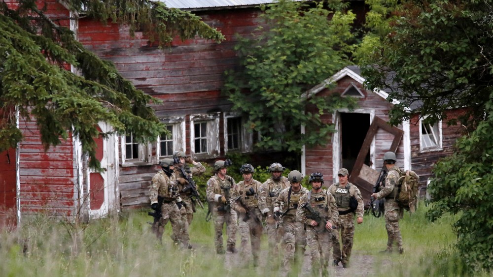 Police officers search a property near the Clinton Correctional Facility in Dannemora, New York, June 8, 2015. (Photo by Chris Wattie/Reuters)