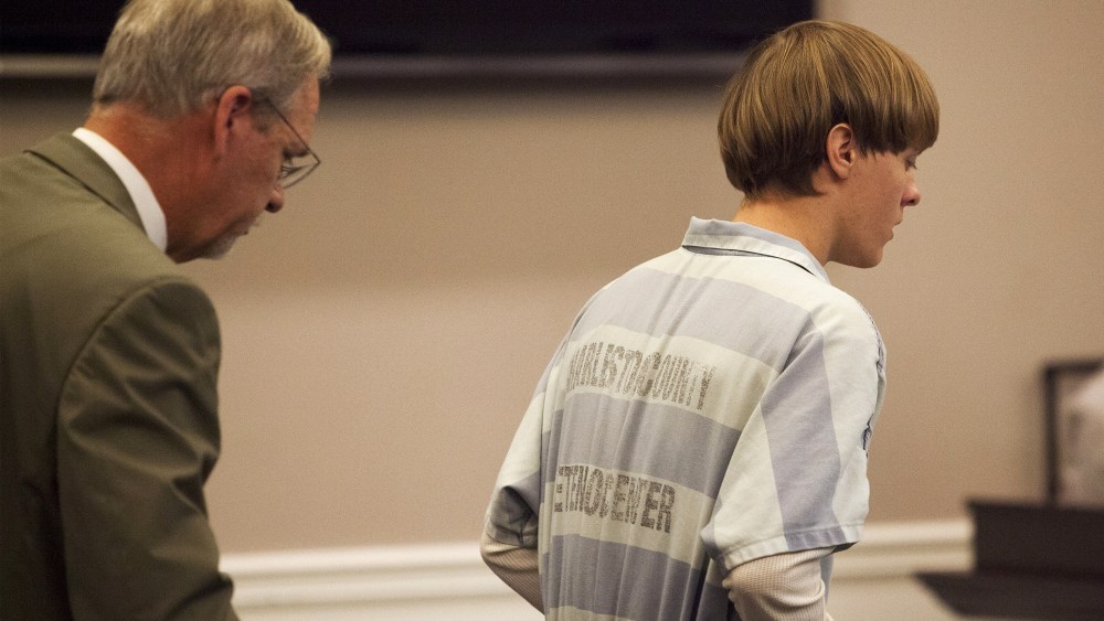 Dylann Roof (R), the 21-year-old man charged with murdering nine worshippers at a historic black church in Charleston last month, is helped to his chair by chief public defender Ashley Pennington during a hearing at the Judicial Center in Charleston