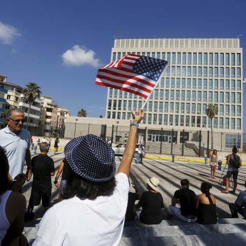 A woman waves a U.S flag in front of the U.S. Interests Section, in Havana, Cuba. (Photo by  Stringer/ Reuters)