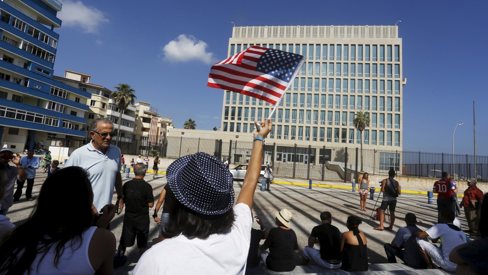 A woman waves a U.S flag in front of the U.S. Interests Section, in Havana, Cuba. (Photo by  Stringer/ Reuters)