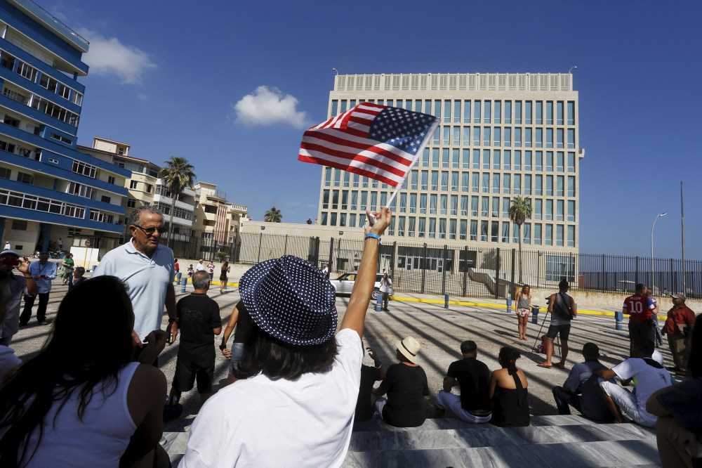 A woman waves a U.S flag in front of the U.S. Interests Section, in Havana, Cuba. (Photo by  Stringer/ Reuters)