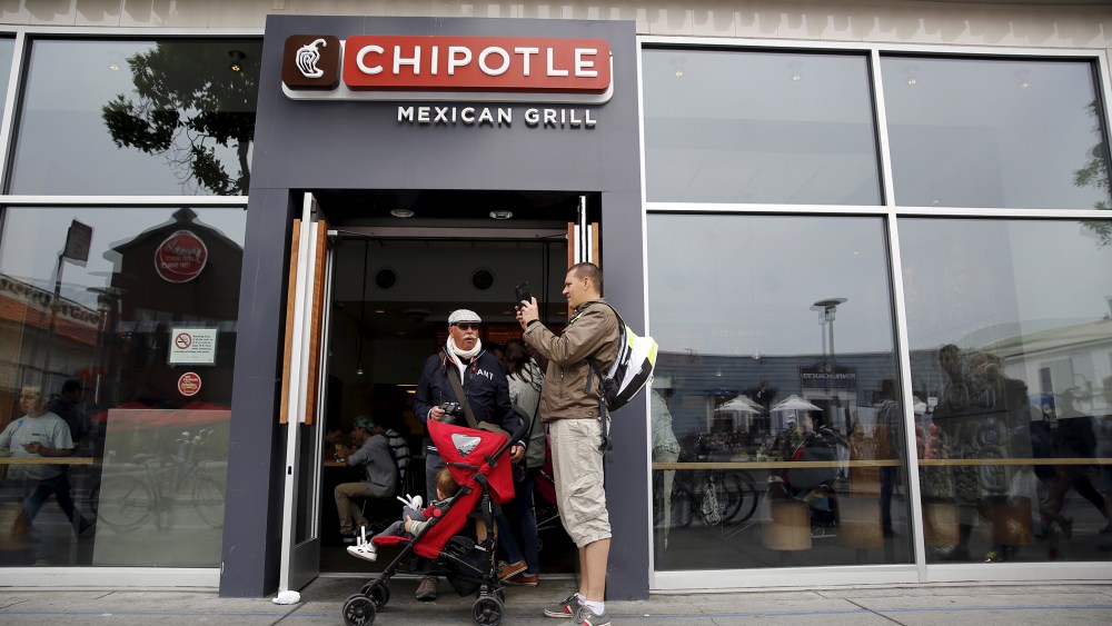 A man snaps a photograph at the entrance to Chipotle Mexican Grill in San Francisco, Calif., July 21, 2015. (Photo by Robert Galbraith/Reuters)