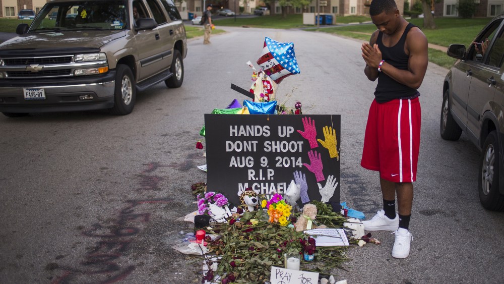 Local resident Ken Kendricks Jr. puts his hands together in prayer at a makeshift memorial at the site along Canfield Road where unarmed teen Michael Brown was shot dead in Ferguson, Mo., Aug. 22, 2014. (Photo by Adrees Latif/Reuters)