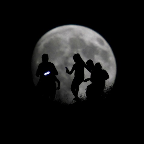 A group of hikers are seen silhouetted against the moon in Tijuana, Mexico, Aug. 27, 2015. (Photo by Jorge Duenes/Reuters)