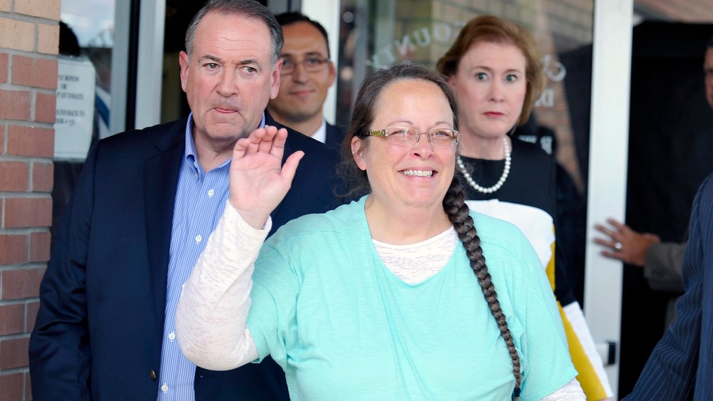 Kim Davis, flanked by Republic presidential candidate Mike Huckabee waves as she walks out of jail, Sep. 8, 2015. (Photo by Chris Tilley/Reuters)