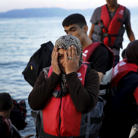 A Syrian refugee reacts while travelling in an overcrowded dinghy as it arrives at a beach on the Greek island of Lesbos, after crossing part of the Aegean Sea from Turkey, Sept. 25, 2015. (Photo by Yannis Behrakis/Reuters)