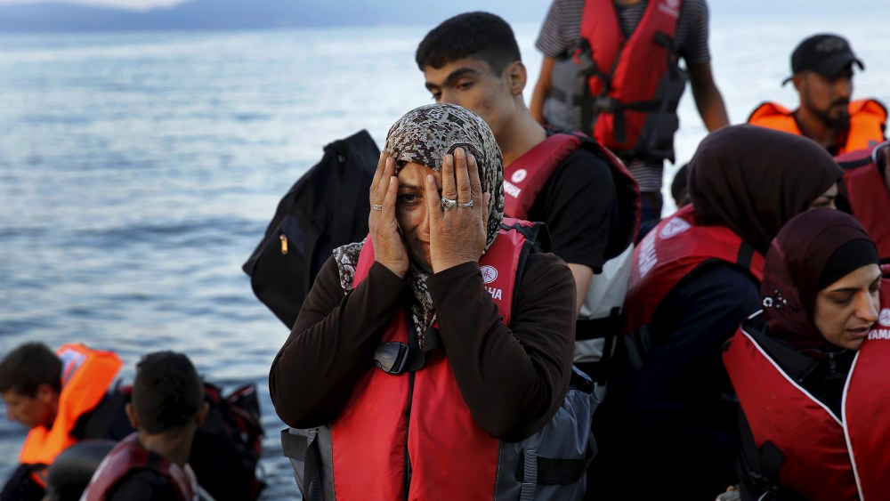 A Syrian refugee reacts while travelling in an overcrowded dinghy as it arrives at a beach on the Greek island of Lesbos, after crossing part of the Aegean Sea from Turkey, Sept. 25, 2015. (Photo by Yannis Behrakis/Reuters)