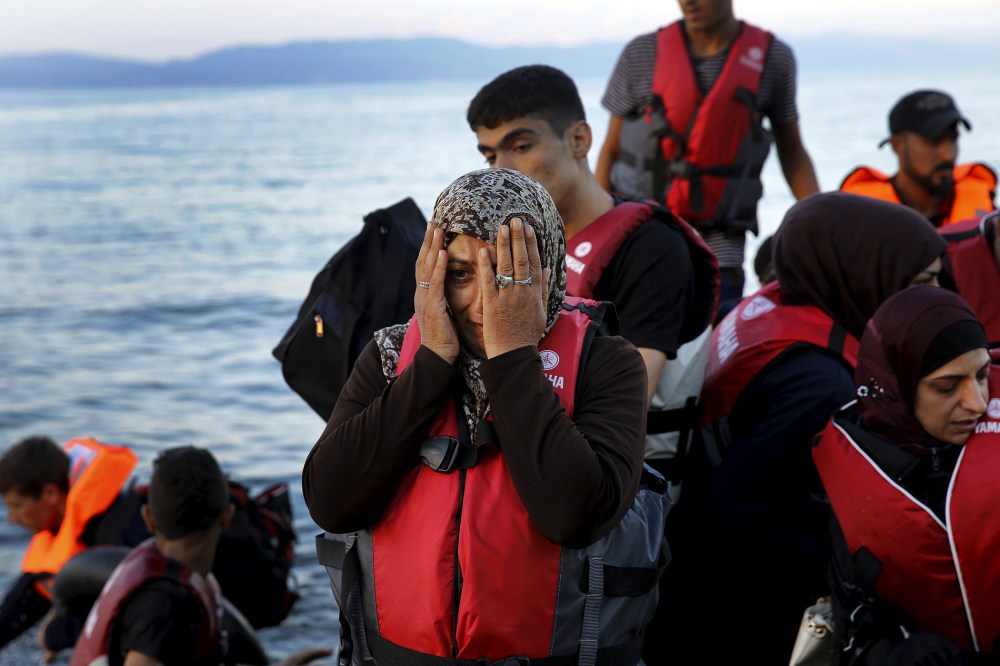 A Syrian refugee reacts while travelling in an overcrowded dinghy as it arrives at a beach on the Greek island of Lesbos, after crossing part of the Aegean Sea from Turkey, Sept. 25, 2015. (Photo by Yannis Behrakis/Reuters)