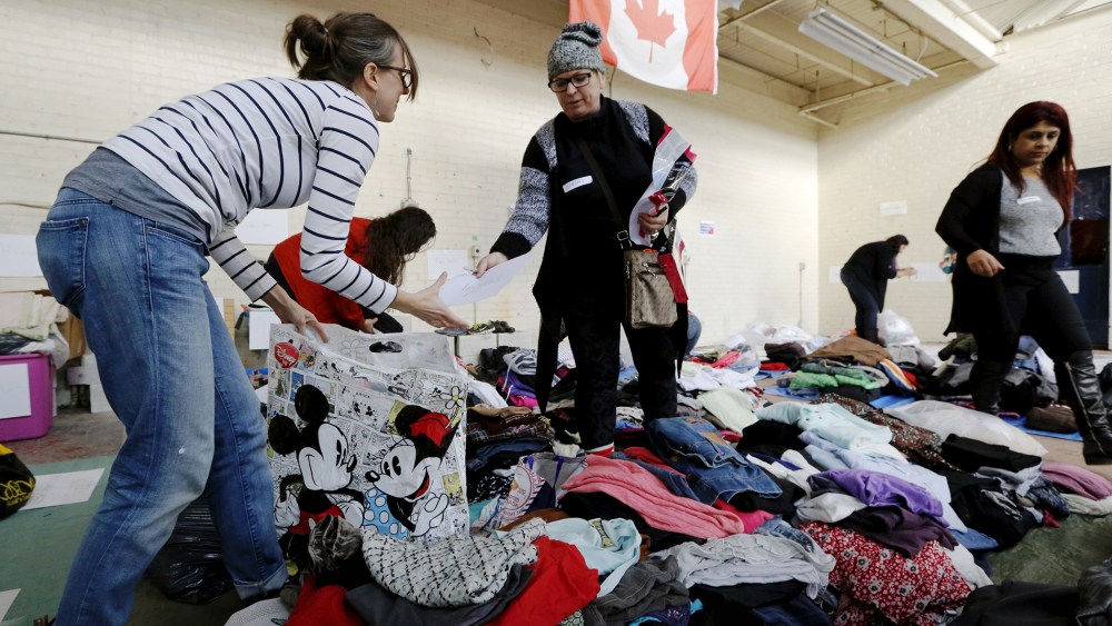 Clothing donated for an expected influx of Syrian refugees is sorted by volunteers for size and gender at a theatre rehearsal space in Toronto, Canada, Nov. 24, 2015. (Photo by Chris Helgren/Reuters)