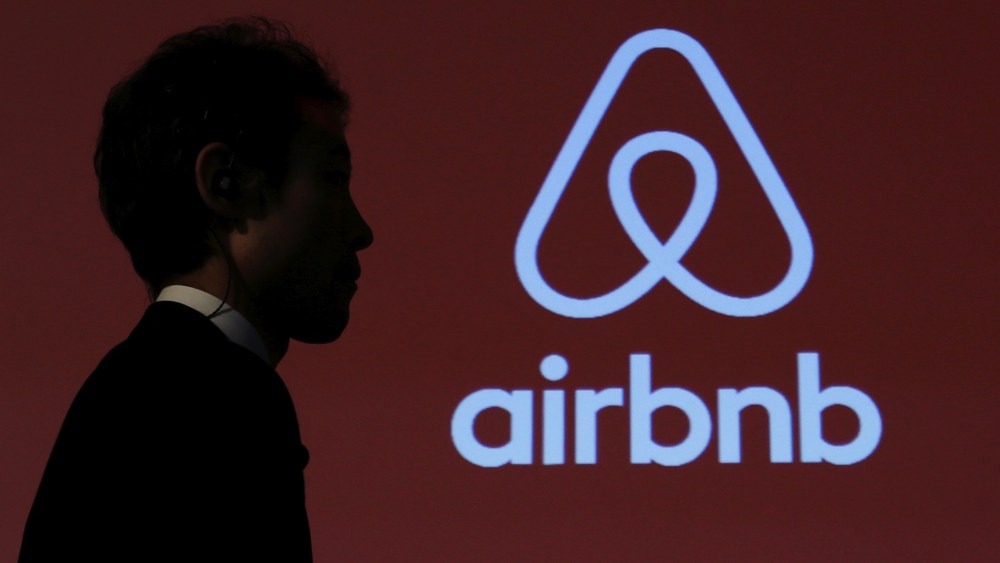 A man walks past a logo of Airbnb after a news conference in Tokyo, Japan, Nov. 26, 2015. (Photo by Yuya Shino/Reuters)