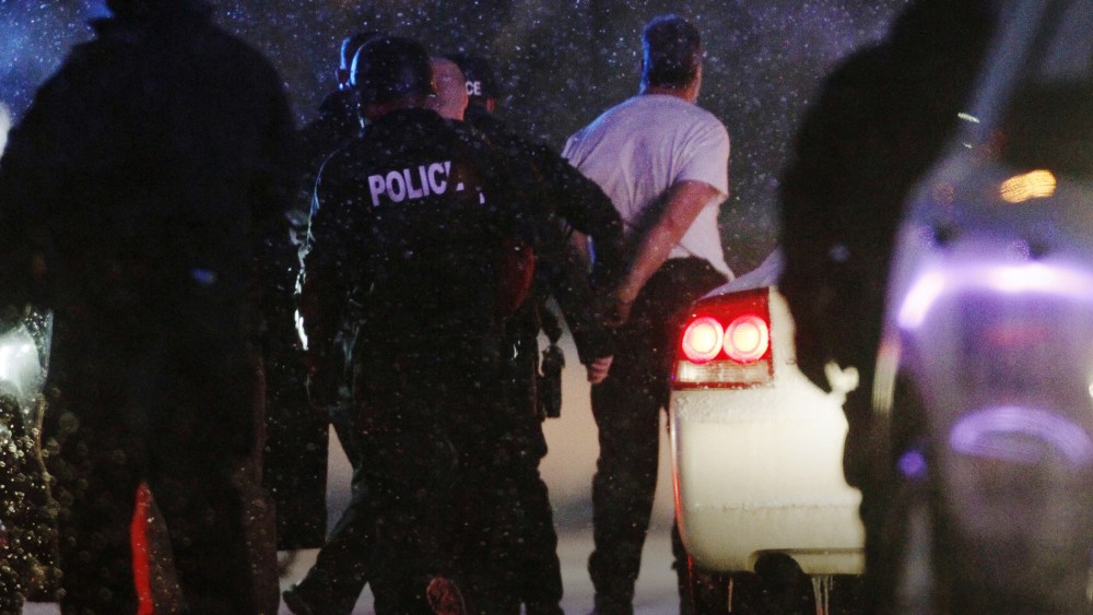 The handcuffed suspected gunman at the Planned Parenthood clinic is moved to a police vehicle in Colorado Springs, Colo., Nov. 27, 2015. (Photo by Rick Wilking/Reuters)