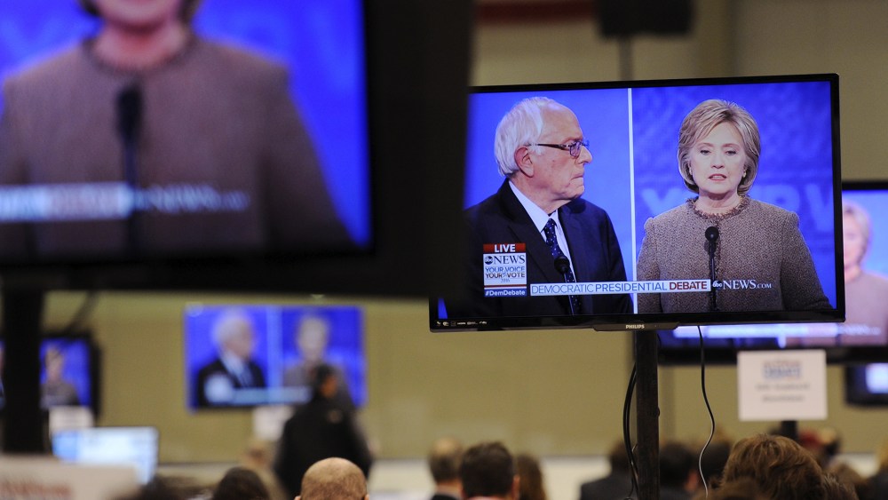Democratic presidential candidates Hillary Clinton and Bernie Sanders appear on screens in the media room during the debate held at Saint Anselm College in Manchester, N.H., Dec. 19, 2015. (Photo by Gretchen Ertl/Reuters)
