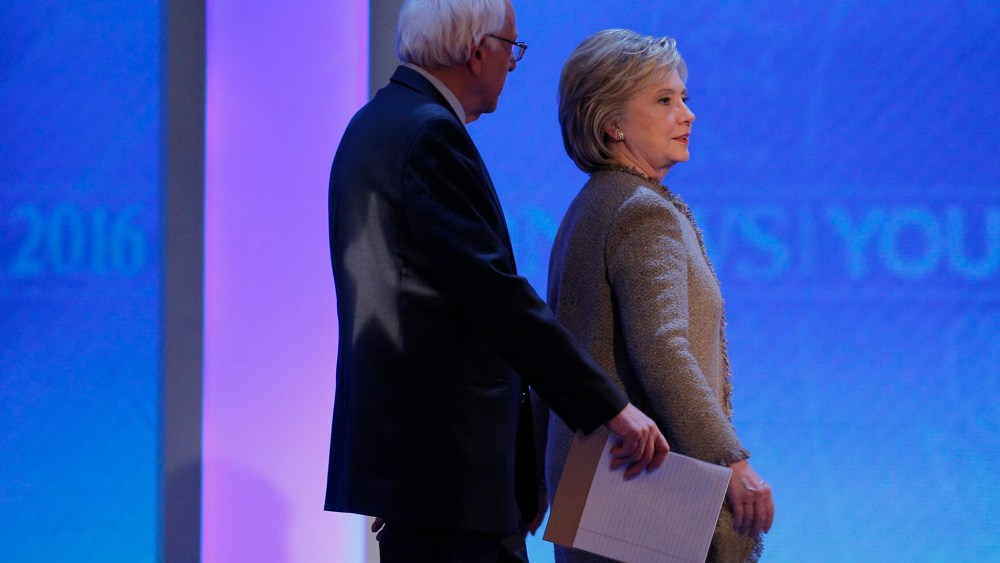 Democratic presidential candidates Bernie Sanders and Hillary Clinton talk as they return to the stage together at the end of a commercial break at presidential debate, Manchester, N.H. Dec. 19, 2015. (Photo by Brian Snyder/Reuters)