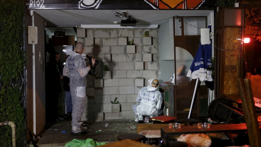Israeli forensic policemen work at the scene of a shooting incident in Tel Aviv, Israel, Jan. 1, 2016. (Photo by Baz Ratner/Reuters)